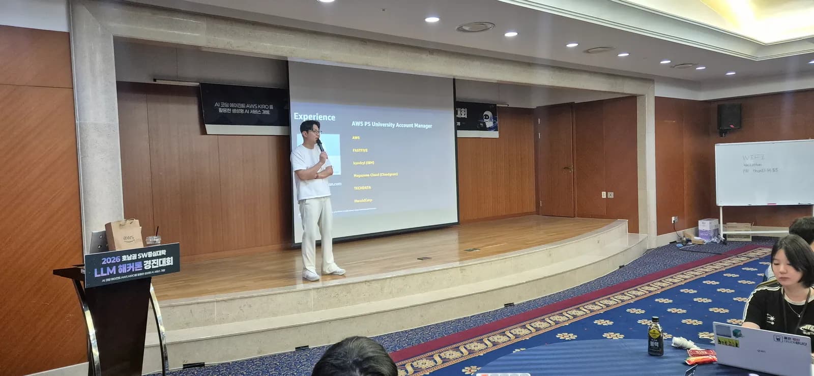 AWS 담당자가 무대에서 지원 범위와 계정 문의 창구를 안내하는 모습