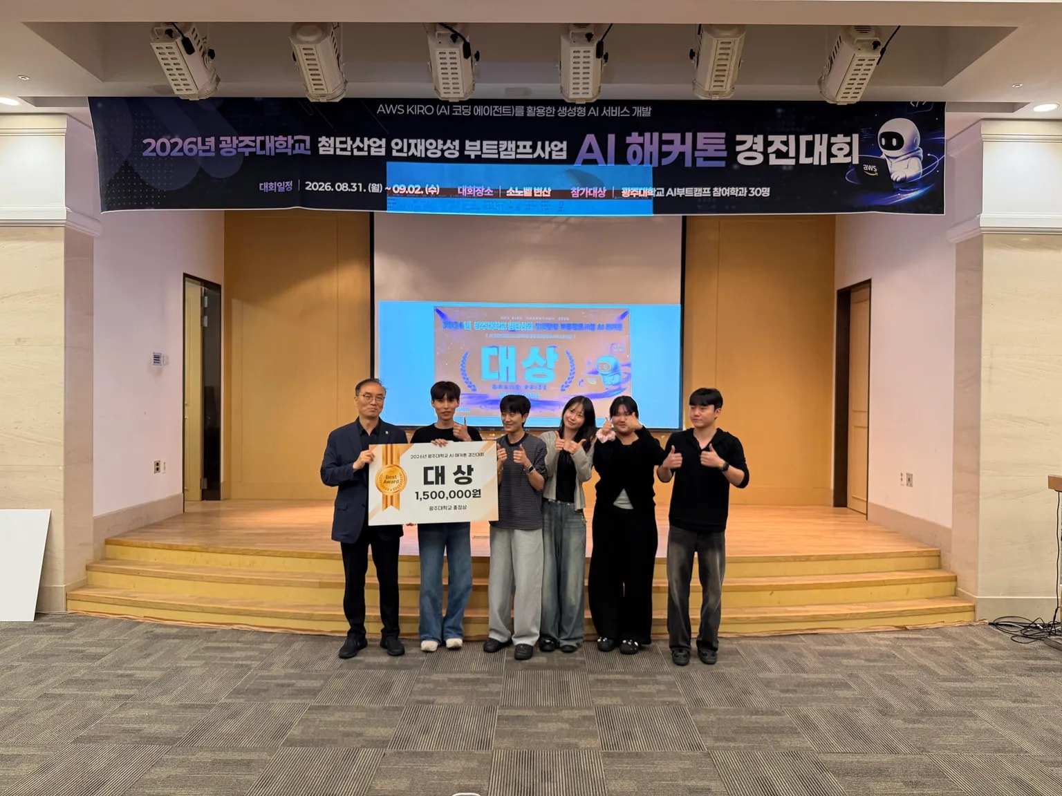 대상 상패를 든 수상 팀과 무대 현수막